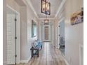 Bright hallway featuring modern light fixtures, tile flooring, and access to various rooms at 29363 N 132Nd Ln, Peoria, AZ 85383