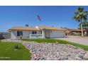 Well-manicured front yard features beautiful rock landscaping, green grass and a view of the house at 4621 E Mineral Rd, Phoenix, AZ 85044