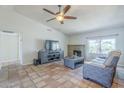 Cozy living room featuring a ceiling fan, entertainment center, brick fireplace, and tiled floors at 4621 E Mineral Rd, Phoenix, AZ 85044