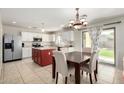 Well-lit eat-in kitchen with white cabinets, granite countertops, stainless steel appliances, and tile floors at 567 E Bradstock Way, Queen Creek, AZ 85140