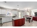 Bright, open kitchen with a kitchen island, stainless steel sink and appliances, and adjacent dining area at 567 E Bradstock Way, Queen Creek, AZ 85140