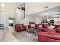 Bright and airy living room with high ceilings, neutral tile flooring, and comfortable seating arrangement at 567 E Bradstock Way, Queen Creek, AZ 85140