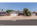 Inviting single-story home with a two-car garage and desert landscaping in the front yard at 6110 E Ivyglen St, Mesa, AZ 85205