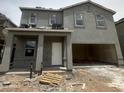 Two-story home featuring stucco facade and a covered entryway, awaiting finishing touches at 1998 E Bucking Bronco Dr, San Tan Valley, AZ 85140