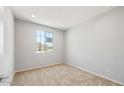 A carpeted room bathed in sunlight from a large window at 26992 W Melinda Ln, Buckeye, AZ 85396