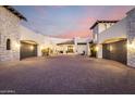Grand stucco home featuring a wide paved driveway and multiple garage entrances at 36075 N Summit Dr, Cave Creek, AZ 85331