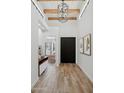 Inviting entryway with wood floors, a dark wood front door, and bright white walls, with a chandelier at 5756 N 78Th Pl, Scottsdale, AZ 85250