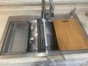 Stainless steel sink with a modern faucet, integrated cutting board, and dish rack at 8009 S 53Rd Ave, Laveen, AZ 85339