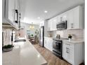 Bright kitchen featuring white cabinets, stainless steel appliances, and modern countertops at 10502 W Hutton Dr, Sun City, AZ 85351