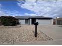 Well-maintained single-story home with tidy landscaping, a two-car garage, and wide driveway at 10852 N 39Th Ave, Phoenix, AZ 85029
