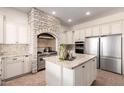 Modern kitchen with white cabinets, stainless steel appliances, and a brick alcove housing the stove and oven at 14188 W Hope Dr, Surprise, AZ 85379