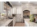 Gourmet kitchen showcasing granite countertops, stainless steel appliances, and a unique brick cooking alcove at 14188 W Hope Dr, Surprise, AZ 85379