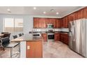 Modern kitchen with stainless steel appliances, granite countertops, and a spacious island with bar seating at 16022 W Desert Mirage Dr, Surprise, AZ 85379