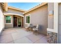 Inviting front patio with comfortable seating, stone accents, and an elegant entrance at 17054 W Saguaro Park Ln, Surprise, AZ 85387