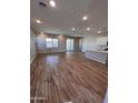 Bright, open-concept living area features wood look flooring, recessed lighting, and a sliding glass door at 18225 W Larkspur Dr, Goodyear, AZ 85338
