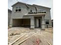 Unfinished two-story home with a two-car garage and a covered entryway, set against a bright, overcast sky at 1984 E Bucking Bronco Dr, San Tan Valley, AZ 85140
