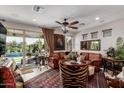 Elegant living room with leather sofa, chandelier, and large sliding doors showcasing a beautiful backyard and pool at 20839 E Kingbird Dr, Queen Creek, AZ 85142