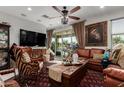 Inviting living room with stylish decor, comfortable leather seating, a large TV, and sliding doors to outdoor space at 20839 E Kingbird Dr, Queen Creek, AZ 85142