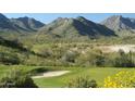 Scenic golf course view with lush green fairways and stunning mountain backdrop at 20847 W Montebello Ave, Buckeye, AZ 85396