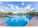 Large community pool with splash pad, lounge seating and desert landscaping at 21412 W Hubbell St, Buckeye, AZ 85396