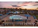 Stunning aerial view of the community pool and amenity center at sunset, with ample seating and palm trees at 21564 W Pierson St, Buckeye, AZ 85396