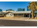 Lovely one-story home with a covered carport, mature landscaping, and a freshly manicured lawn at 2544 E Elm St, Phoenix, AZ 85016