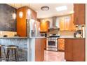 Eat-in kitchen featuring wooden cabinets, stainless steel appliances and stone accented bar at 2715 E Edgemont Ave, Phoenix, AZ 85008