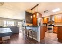Eat-in kitchen featuring wooden cabinets, stainless steel appliances and stone accented bar at 2715 E Edgemont Ave, Phoenix, AZ 85008