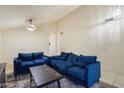 Open-concept living room featuring comfortable blue sofas, ceiling fan, and neutral decor at 3015 S Woodruff Dr, Mesa, AZ 85212