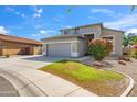 Beautiful home featuring a well-manicured lawn and colorful bushes by the front with a gray two-car garage at 345 N Scott Dr, Chandler, AZ 85225