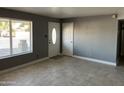 Open entryway featuring neutral tile flooring, freshly painted walls, and updated front door with oval window at 3539 W Davidson Ln, Phoenix, AZ 85051