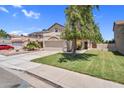Exterior view of a beige two-story home with well-maintained lawn, complemented by lush greenery and a driveway at 3608 W Harrison St, Chandler, AZ 85226