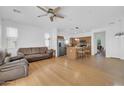 Open-concept living room with wood floors flows into the kitchen with an island, and a ceiling fan at 3745 E Flamingo Way, Gilbert, AZ 85297