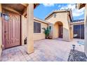 Welcoming front porch with decorative columns, dual doors, and pavers for a stylish outdoor space at 42318 W Abbey Rd, Maricopa, AZ 85138