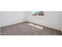 A sunny bedroom with neutral carpet and a view of another home through the window at 5106 E Midnight Star Dr, San Tan Valley, AZ 85143