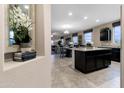 Modern kitchen island featuring granite countertops and dark cabinetry overlooking the living area at 5106 E Midnight Star Dr, San Tan Valley, AZ 85143