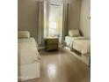 Bright bedroom with two beds, a central nightstand, and natural light filtering through the window at 7136 N 73Rd Dr, Glendale, AZ 85303
