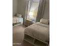 Cozy bedroom featuring two twin beds with modern white storage frames and a stylish nightstand at 7136 N 73Rd Dr, Glendale, AZ 85303