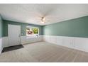 Bright living room with neutral carpet, decorative chair railing, ceiling fan, and large window for natural light at 8020 E Keats Ave # 285, Mesa, AZ 85209