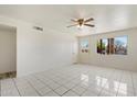 Bright living room features tile flooring and natural light streaming through a window with backyard view at 946 S Pomeroy Cir, Mesa, AZ 85210