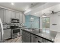 Modern kitchen showcasing stainless steel appliances, gray cabinets, granite counters, and chic pendant lighting at 1056 N Miller Rd, Tempe, AZ 85288