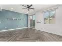 Bright living room features stylish gray herringbone floors, a ceiling fan, and a sliding glass door at 1056 N Miller Rd, Tempe, AZ 85288