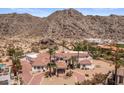 Expansive desert home with a pool, lush landscaping, and mountain backdrop at 11809 S Montezuma Ct, Phoenix, AZ 85044