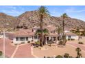 Impressive desert home with a circular driveway and manicured landscaping at 11809 S Montezuma Ct, Phoenix, AZ 85044