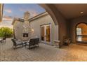 Covered patio with stone fireplace and outdoor seating, perfect for entertaining at 12006 E Yucca St, Scottsdale, AZ 85259