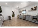 Well-lit kitchen with stainless steel appliances, gray cabinetry, white walls, and hardwood floors at 1246 E Cambridge Ave, Phoenix, AZ 85006