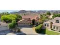 Beautiful aerial view of a desert home with a tile roof, three car garage, lush landscaping, and mountain views at 14034 S 34Th Pl, Phoenix, AZ 85044