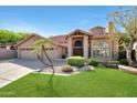 Charming home featuring a three-car garage, tile roof, lush green lawn, and desert landscaping at 14034 S 34Th Pl, Phoenix, AZ 85044