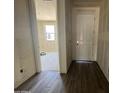 Hallway features beautiful wood-style tile flooring and a view into the unfurnished living area at 15785 W Cheryl Dr, Waddell, AZ 85355