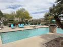 Inviting community pool with sun loungers, lush landscaping, and pergola at 16013 S Desert Foothills Pkwy # 2056, Phoenix, AZ 85048